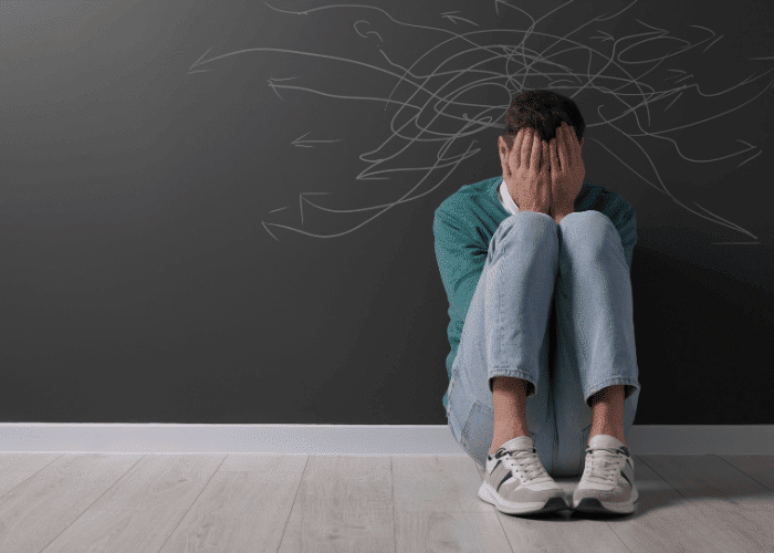 Man sitting with his knees to his chest due to lack of mental health awareness
