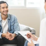 Man smiling during therapy session with female practitioner