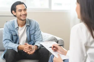 Man smiling during therapy session with female practitioner