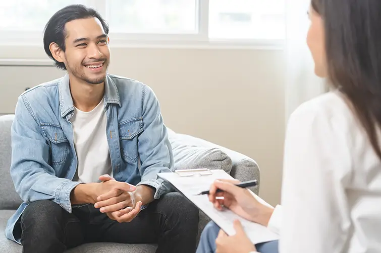 Man smiling during therapy session with female practitioner